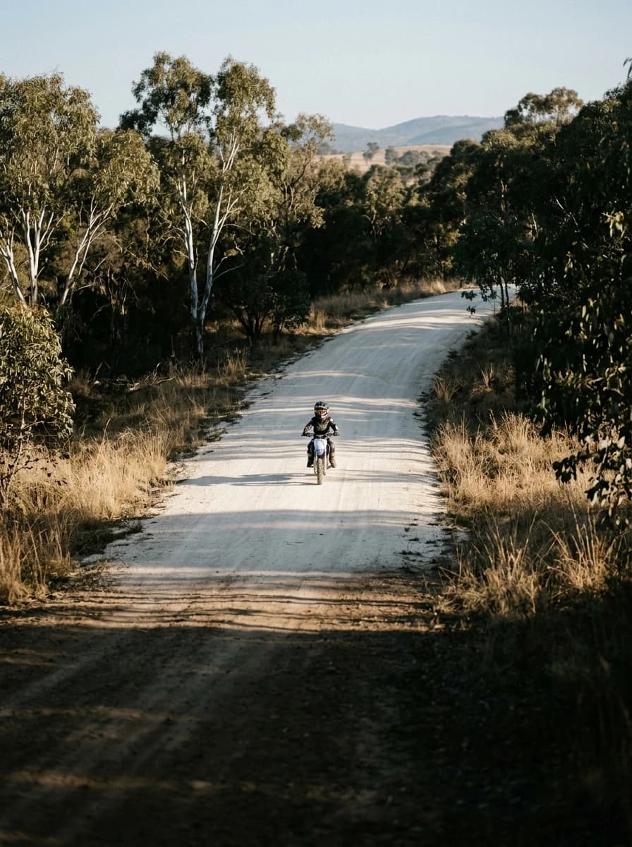 Young rider on a wide beginner track through the bush at EMX Riders